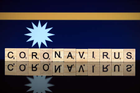 WROCLAW, POLAND - MARCH 28, 2020: Word CORONAVIRUS made of wooden letters, and Nauru Flag in the background. Coronavirus (COVID-19) global disease 2020.のeditorial素材