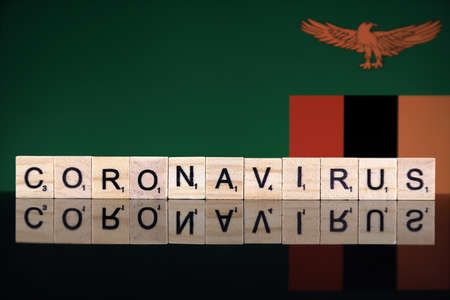 WROCLAW, POLAND - MARCH 28, 2020: Word CORONAVIRUS made of wooden letters, and Zambia Flag in the background. Coronavirus (COVID-19) global disease 2020.のeditorial素材