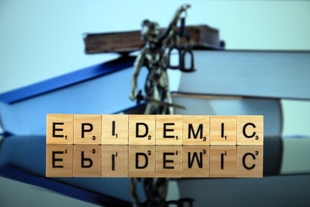 WROCLAW, POLAND - MARCH 30, 2020: The word EPIDEMIC made of wooden letters, and symbol of law and justice in the background. Coronavirus (COVID-19) global disease 2020.のeditorial素材