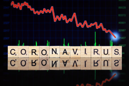 WROCLAW, POLAND - MARCH 30, 2020: The word CORONAVIRUS made of wooden letters, and economic crisis stock chart falling down in the background. Coronavirus (COVID-19) global disease 2020.のeditorial素材