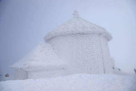 KARPACZ, POLAND - MARCH 08, 2020: St. Lawrence's Chapel in the Winter. A Roman Catholic chapel located on the peak of Sniezka mountain (1602 m. above sea level), Giant Mountains, Poland, Europe.のeditorial素材