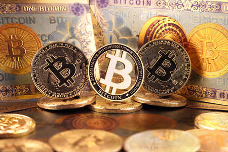 A physical version of Bitcoin in the form of coins and banknotes. A conceptual image for investors in the fast-growing cryptocurrency and blockchain technology market.の写真素材