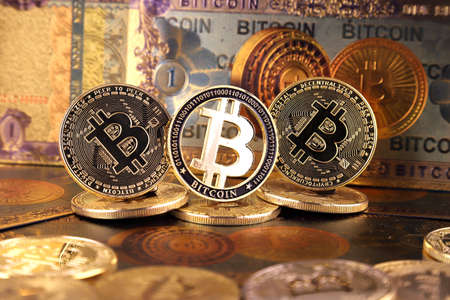 A physical version of Bitcoin in the form of coins and banknotes. A conceptual image for investors in the fast-growing cryptocurrency and blockchain technology market.の写真素材