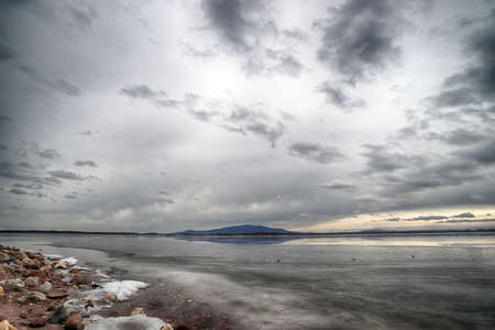 An ice-covered beach by the Mietkowski Lagoon, with the Sleza Mountain in the background. Mietkow near Wroclaw, Poland, Europe.の写真素材