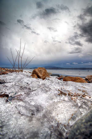 An ice-covered beach by the Mietkowski Lagoon, with the Sleza Mountain in the background. Mietkow near Wroclaw, Poland, Europe.の写真素材