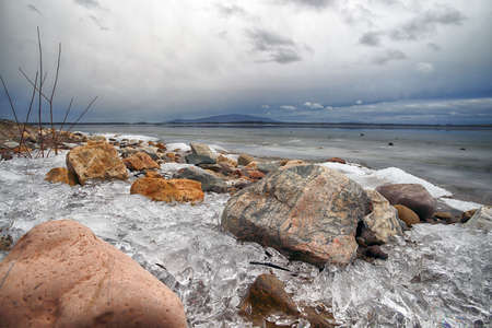 An ice-covered beach by the Mietkowski Lagoon, with the Sleza Mountain in the background. Mietkow near Wroclaw, Poland, Europe.の写真素材