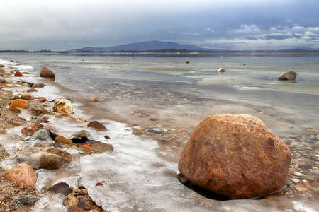 An ice-covered beach by the Mietkowski Lagoon, with the Sleza Mountain in the background. Mietkow near Wroclaw, Poland, Europe.の写真素材