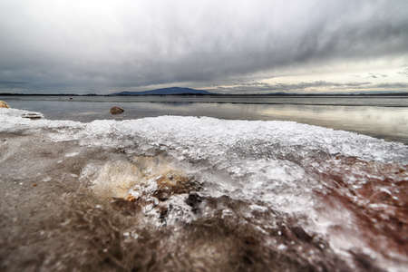 An ice-covered beach by the Mietkowski Lagoon, with the Sleza Mountain in the background. Mietkow near Wroclaw, Poland, Europe.の写真素材