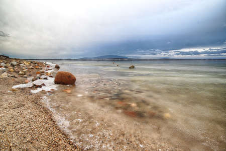 An ice-covered beach by the Mietkowski Lagoon, with the Sleza Mountain in the background. Mietkow near Wroclaw, Poland, Europe.の写真素材