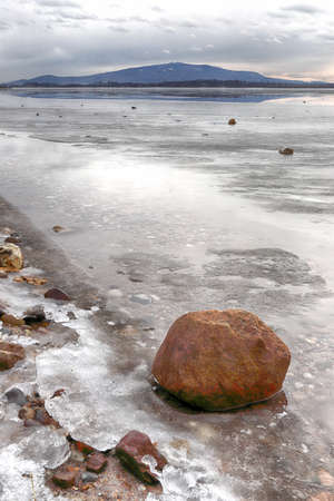 An ice-covered beach by the Mietkowski Lagoon, with the Sleza Mountain in the background. Mietkow near Wroclaw, Poland, Europe.の写真素材