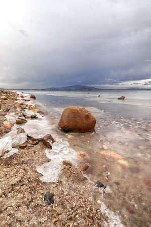 An ice-covered beach by the Mietkowski Lagoon, with the Sleza Mountain in the background. Mietkow near Wroclaw, Poland, Europe.の写真素材