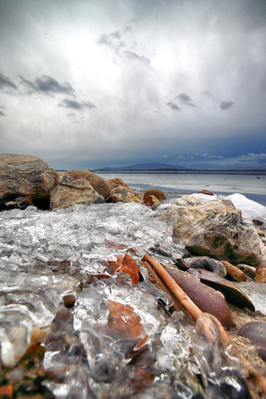 An ice-covered beach by the Mietkowski Lagoon, with the Sleza Mountain in the background. Mietkow near Wroclaw, Poland, Europe.の写真素材