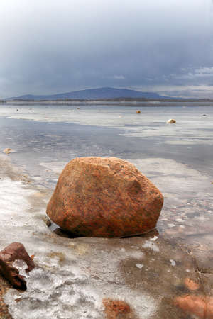 An ice-covered beach by the Mietkowski Lagoon, with the Sleza Mountain in the background. Mietkow near Wroclaw, Poland, Europe.の写真素材