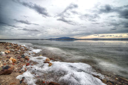 An ice-covered beach by the Mietkowski Lagoon, with the Sleza Mountain in the background. Mietkow near Wroclaw, Poland, Europe.の写真素材