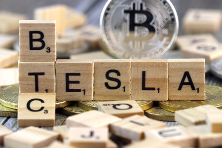 WROCLAW, POLAND - FEBRUARY 10, 2021: Word TESLA and BTC (Bitcoin) made of small wooden letters, and physical version of Bitcoin.のeditorial素材