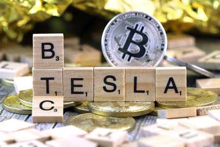 WROCLAW, POLAND - FEBRUARY 10, 2021: Word TESLA and BTC (Bitcoin) made of small wooden letters, and physical version of Bitcoin.のeditorial素材