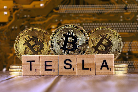WROCLAW, POLAND - FEBRUARY 10, 2021: Word TESLA made of small wooden letters, and physical version of Bitcoin.のeditorial素材