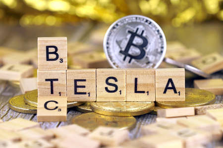 WROCLAW, POLAND - FEBRUARY 10, 2021: Word TESLA and BTC (Bitcoin) made of small wooden letters, and physical version of Bitcoin.のeditorial素材
