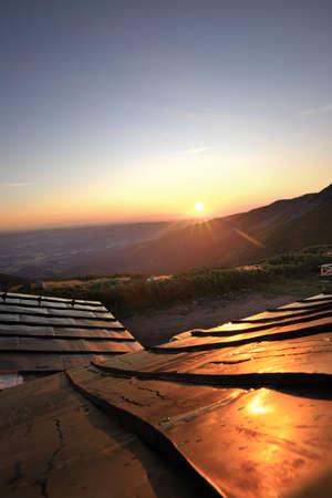 Sunrise illuminating the roof of the mountain shelter Dom Slaski (1400 meters above sea level). Karkonosze National Park, Giant Mountains, Poland, Europe.の写真素材