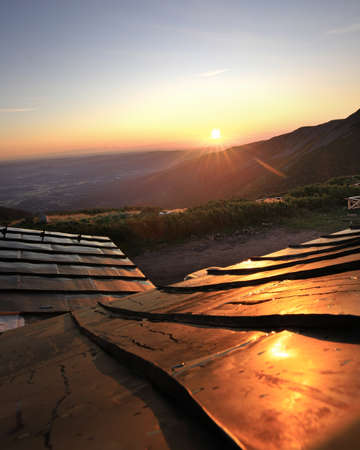 Sunrise illuminating the roof of the mountain shelter Dom Slaski (1400 meters above sea level). Karkonosze National Park, Giant Mountains, Poland, Europe.の写真素材