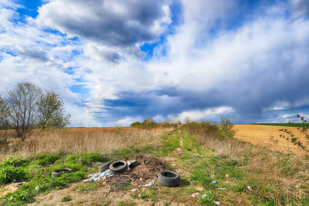 Empty, local road among fields on a stormy day on the last days of April. Spring landscape with beautiful clouds.の写真素材