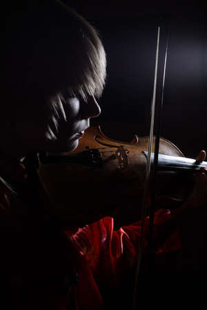 A young woman playing her guitar with expression.の写真素材