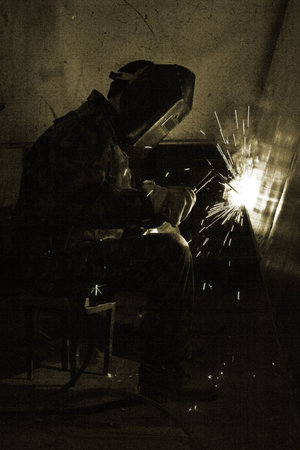 Welder working an industrial background
