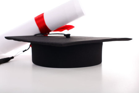 Graduation cap and diploma isolated on white