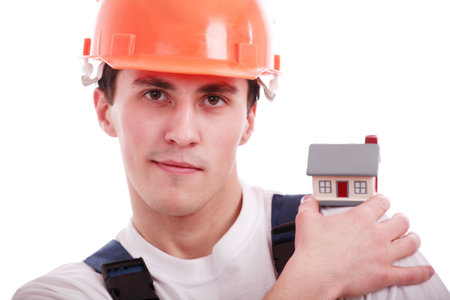 Muscular young man in a builder uniform with tools.