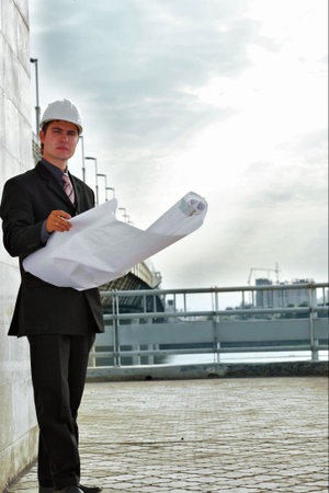 Business background: builder standing at building site.