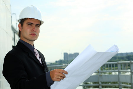 Business background: builder standing at building site.