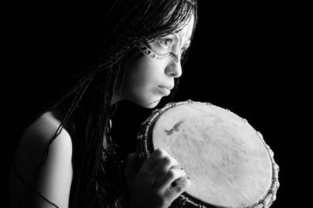 Beautiful ethnic young woman playing a drum.の写真素材