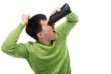 Portrait of a young man looking through a binocular. Theme: education career, success.の写真素材