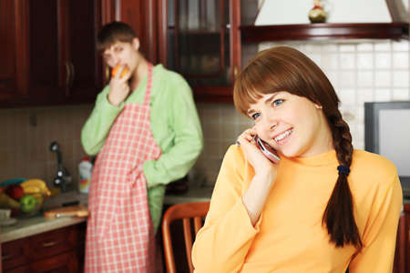 Happy young couple on a kitchen at home.の写真素材