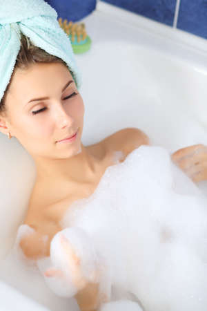 Portrait of a beautiful young woman in a bathroom.の写真素材