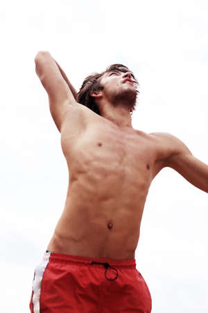 Portrait of a young man playing volleyball on a beach.の写真素材