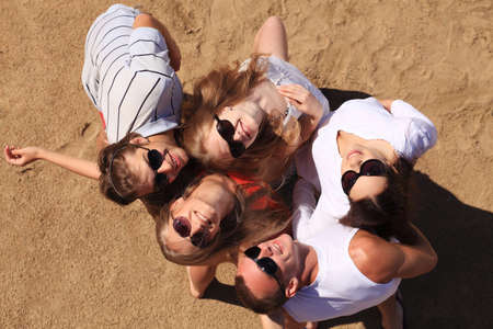 Cheerful young people having fun on a beach. Great summer holidays. の写真素材