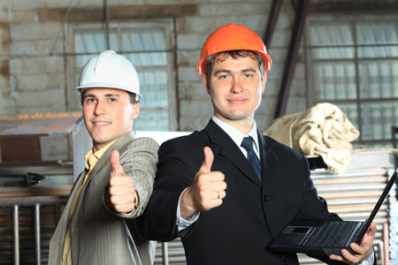Industrial theme: two businessman showing good results at a manufacturing area.  