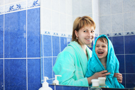 Portrait of a happy mother with her son after bath.の写真素材