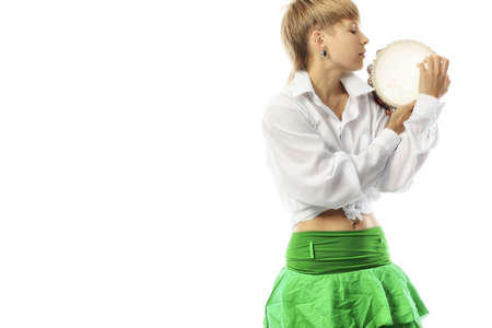 A young woman playing her tambourine with expression.の写真素材