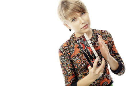 A young woman playing her tambourine with expression.の写真素材