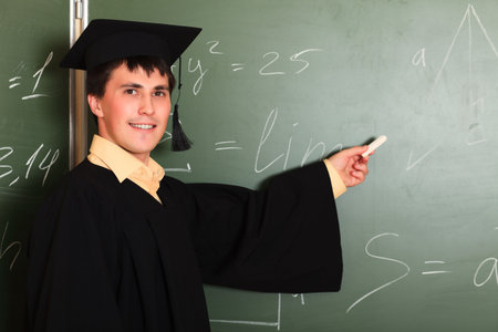 Educational theme: graduating student in academic gown in a classroom.