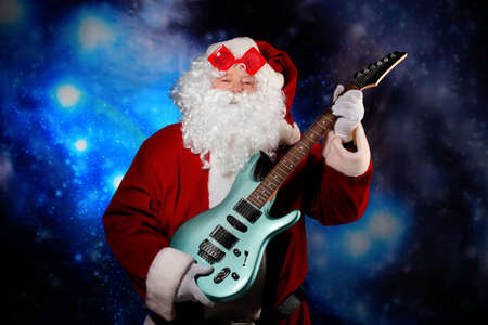 Christmas theme: Santa claus playing a guitar, snowy design.の写真素材