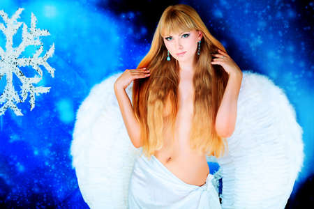 Portrait of a female christmas angel over sky of stars and snow.の写真素材