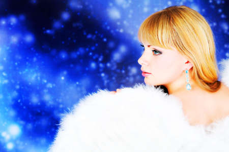 Portrait of a female christmas angel over sky of stars and snow.の写真素材