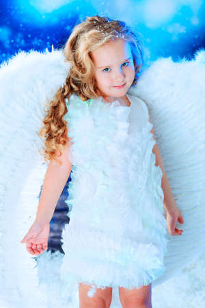 Beautiful little angel at a snowy background.の写真素材