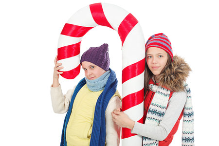 Two happy girls teenagers celebrating christmas together.の写真素材