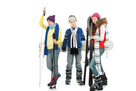 Group of teenagers in warm clothes holding skis and snowboard.の写真素材
