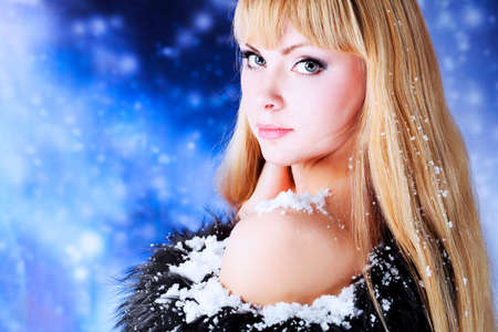 Portrait of a beautiful young woman over sky of stars and snow.の写真素材