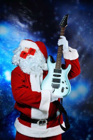 Christmas theme: Santa claus playing a guitar, snowy design.の写真素材